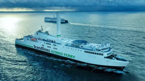 Norsepower Two large, white ferries are seen passing each other in open seas. On the decks is a helideck and a single large rotating tower.