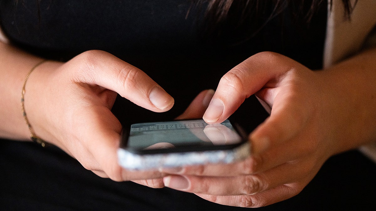 Woman typing on her phone.